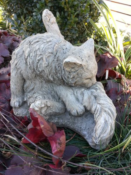 Katze putzt sich aus Steinguss